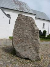 The picture shows the Jelling Stone outside Jelling Church.