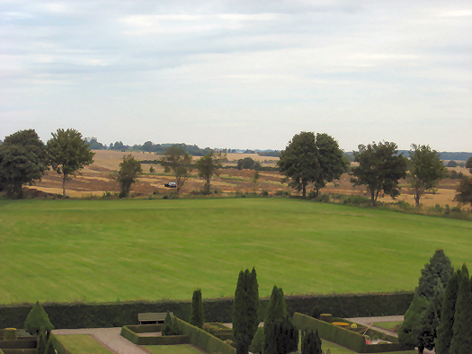 The picture shows the view from the North Mound of trial trenches between the Jelling monuments and the Many Mounds to the north, with green fields in the foreground. Photo: Anne Pedersen.
